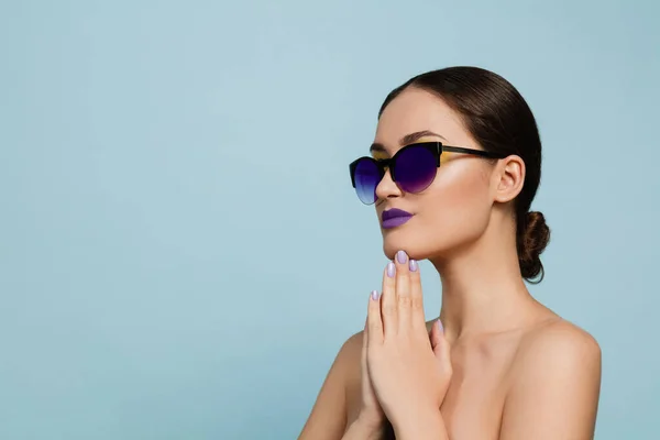 Portrait of beautiful young woman with bright make-up isolated on blue studio background — Stock Photo, Image