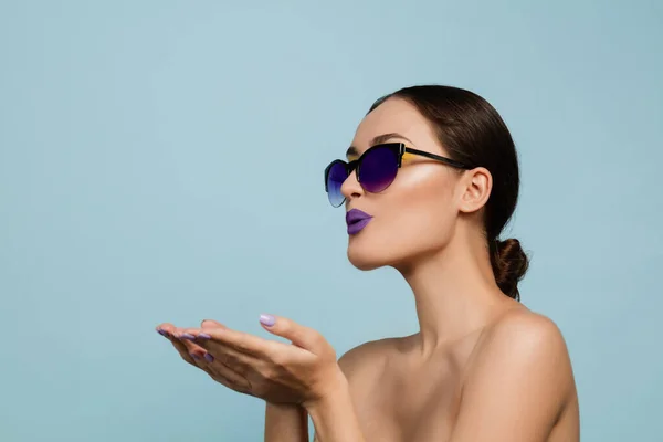 Portret van mooie jonge vrouw met heldere make-up geïsoleerd op blauwe studio achtergrond — Stockfoto