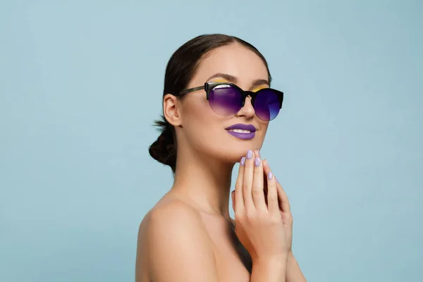 Retrato de una hermosa mujer joven con maquillaje brillante aislado en el fondo azul del estudio — Foto de Stock