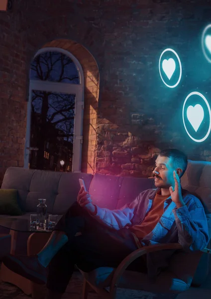 Man using gadget and receive neon notifications at home at night — Stock Photo, Image