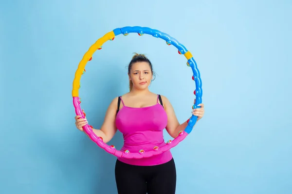 Jonge Kaukasische plus size vrouwelijke modellen training op blauwe achtergrond — Stockfoto