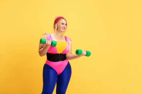 Jeune caucasien plus la taille des modèles féminins formation sur fond jaune — Photo