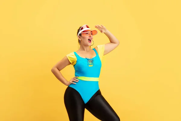 Joven caucásico más tamaño femenino modelos de formación sobre fondo amarillo —  Fotos de Stock