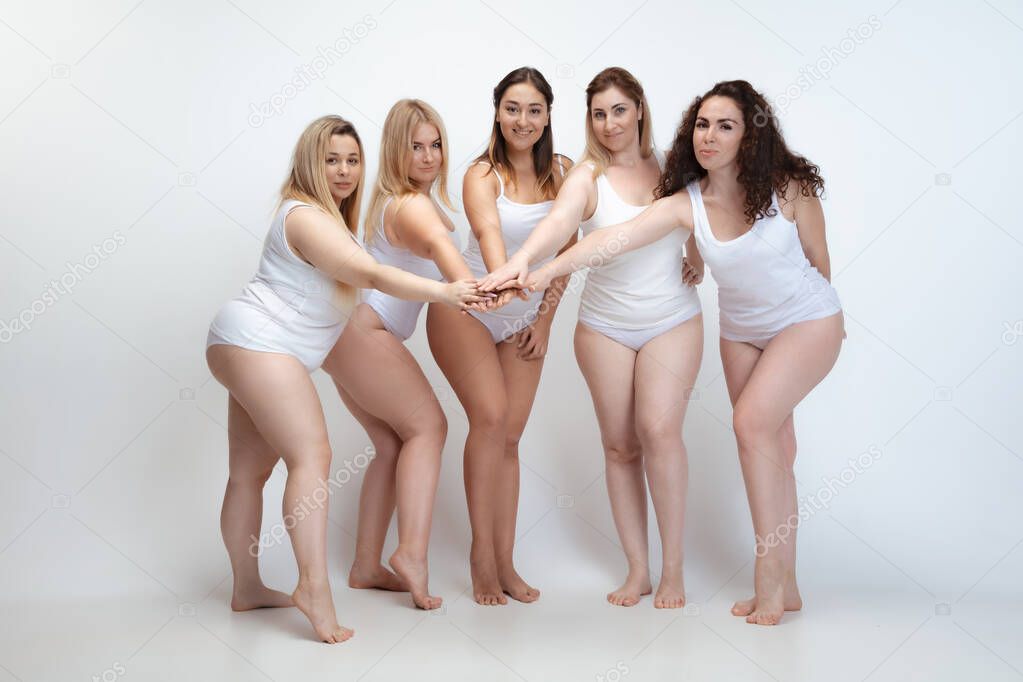 Portrait of beautiful plus size young women posing on white background