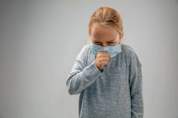 Chica caucásica con la máscara de protección respiratoria contra la contaminación del aire y el atardecer sobre fondo gris estudio — Foto de Stock