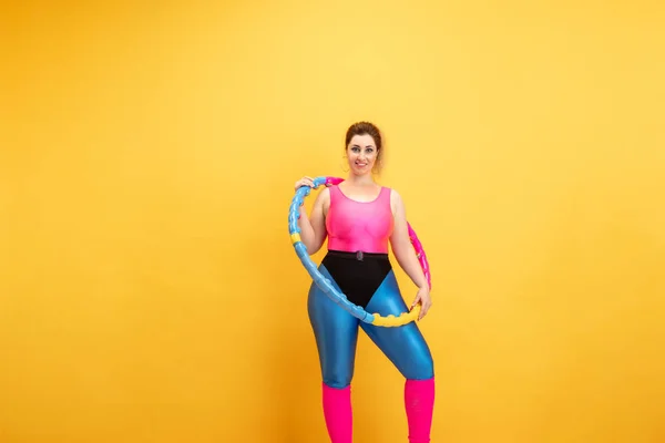 若い白人プラス黄色の背景に女性モデルのトレーニング — ストック写真