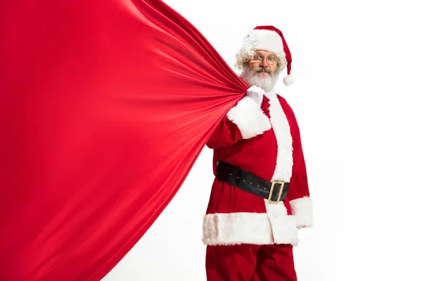 Weihnachtsmann zieht riesige Tasche voller Weihnachtsgeschenke isoliert auf weißem Hintergrund — Stockfoto