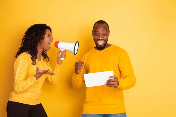 Jeune homme et femme afro-américain émotionnel sur fond jaune — Photo