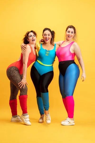 Giovane caucasico plus size femminile modelli di formazione su sfondo giallo — Foto Stock