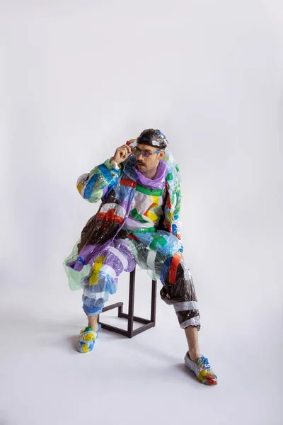 Muž závislý na prodeji a oblečení, nošení plastu, koncepce recyklace — Stock fotografie