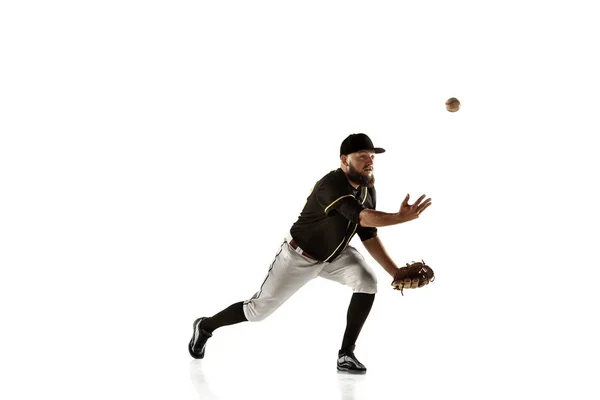 Honkbal speler, werpster in een zwart uniform aan het oefenen op een witte achtergrond. — Stockfoto