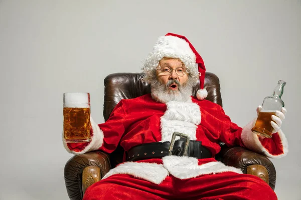 Santa Claus bebiendo cerveza sentado en el sillón, felicitando de Año Nuevo 2020 — Foto de Stock