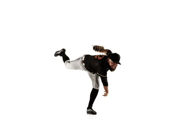 Baseballspieler, Pitcher in schwarzer Uniform beim Üben auf weißem Hintergrund. — Stockfoto