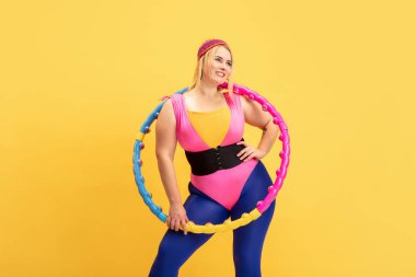 Genç beyaz, artı boyut kadın modeller sarı arka planda eğitim görüyor.