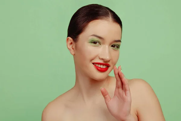 Portret pięknej młodej kobiety z jasnym makijażem odizolowanej na zielonym tle studia — Zdjęcie stockowe