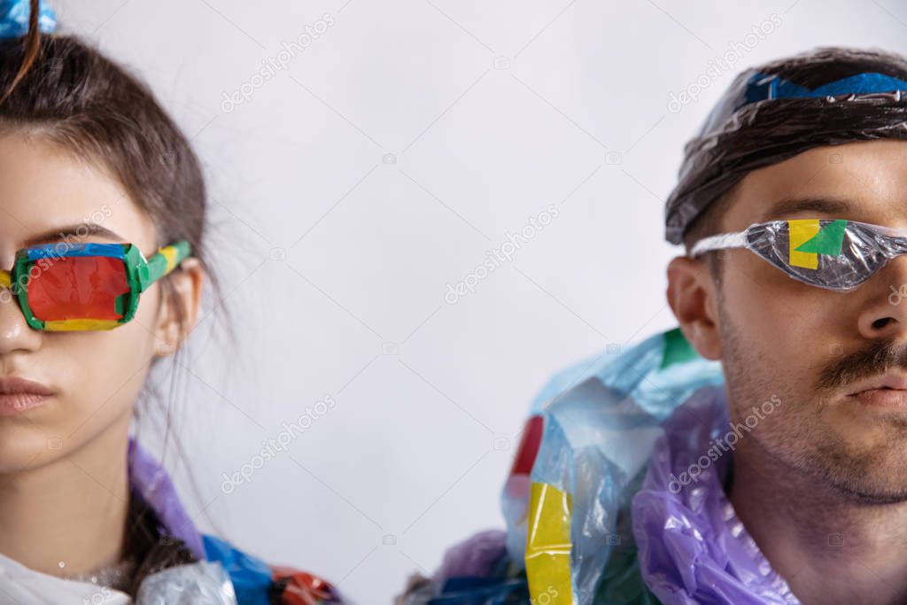 Woman and man addicted of sales and clothes, wearing plastic, recycling concept