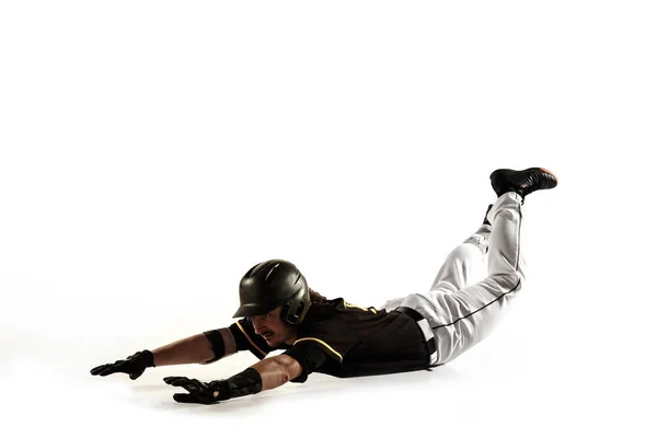 Jogador de beisebol, arremessador de uniforme preto praticando em um fundo branco . — Fotografia de Stock