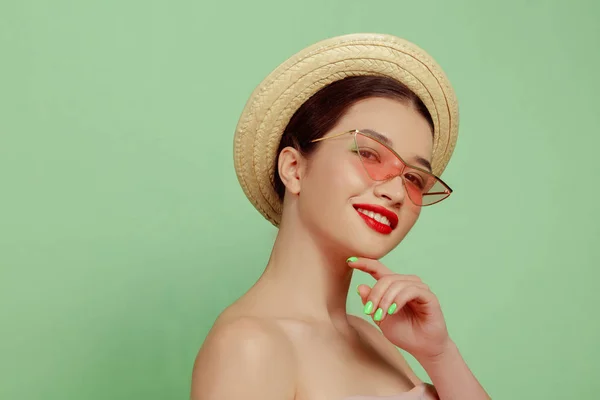 Portrait of beautiful young woman with bright make-up isolated on green studio background — ストック写真