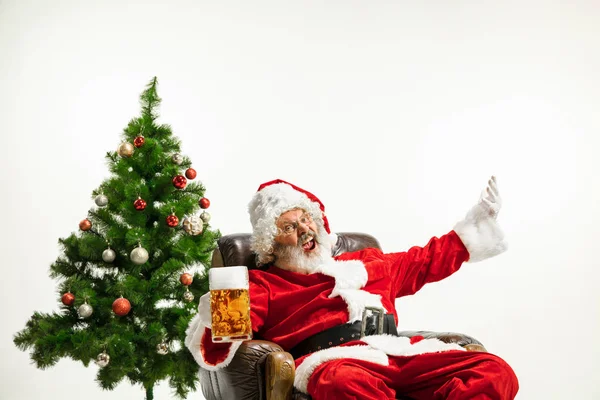 Święty Mikołaj pije piwo w pobliżu choinki, gratulując Nowego Roku 2020 — Zdjęcie stockowe