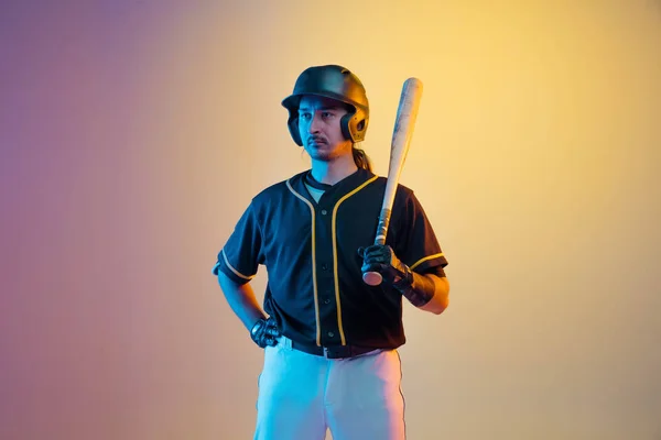 Giocatore di baseball, lanciatore in uniforme nera che pratica su fondo sfumato in luce al neon — Foto Stock