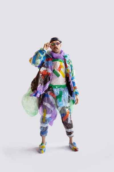 Homem viciado em vendas e roupas, vestindo plástico, conceito de reciclagem — Fotografia de Stock