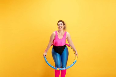 Genç beyaz, artı boyut kadın modeller sarı arka planda eğitim görüyor.