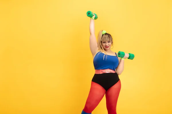 Jeune caucasien plus la taille des modèles féminins formation sur fond jaune — Photo