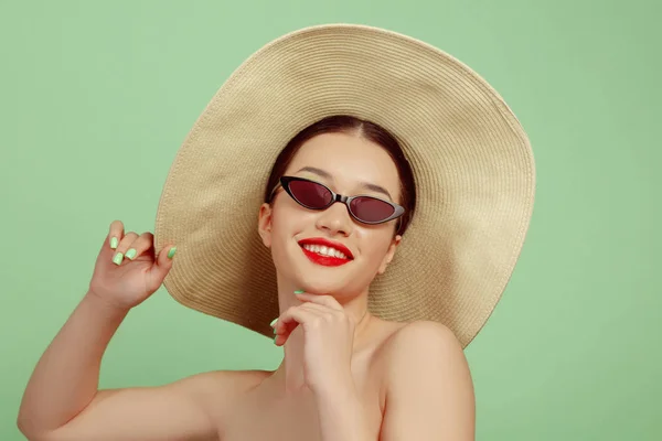 Portret van mooie jonge vrouw met heldere make-up geïsoleerd op groene studio achtergrond — Stockfoto