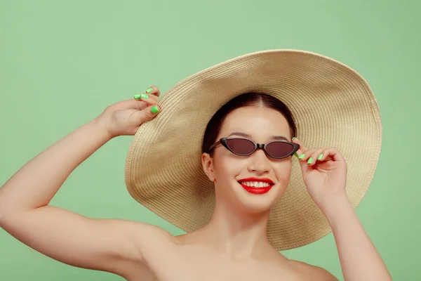 Portret van mooie jonge vrouw met heldere make-up geïsoleerd op groene studio achtergrond — Stockfoto