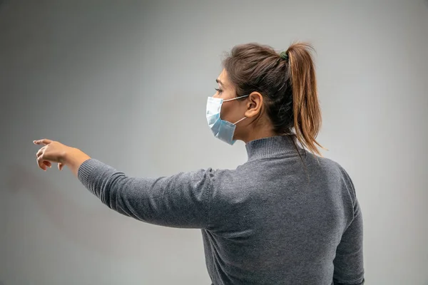 Kaukázusi nő visel légúti védelem maszk légszennyezés ellen, és alkonyat szürke stúdió háttér — Stock Fotó
