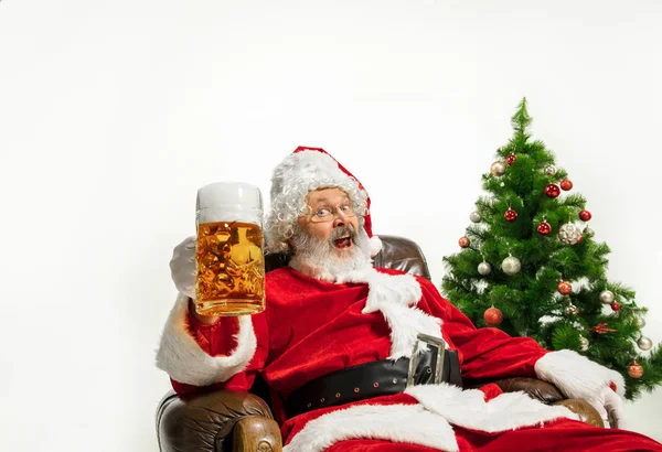 Święty Mikołaj pije piwo w pobliżu choinki, gratulując Nowego Roku 2020 — Zdjęcie stockowe