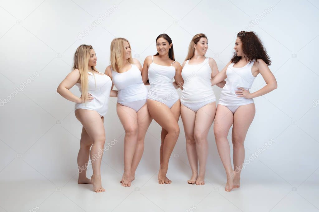 Portrait of beautiful plus size young women posing on white background