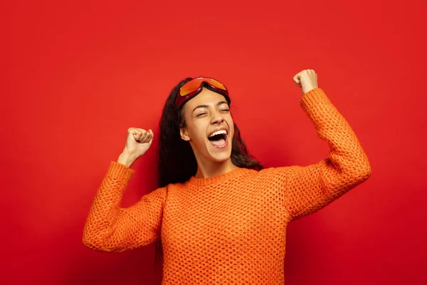 African-american young womans portrait in ski mask on red background
