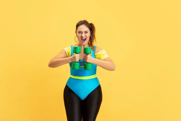 Jeune caucasien plus la taille des modèles féminins formation sur fond jaune — Photo