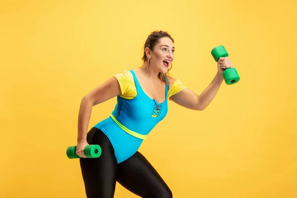 Joven caucásico más tamaño femenino modelos de formación sobre fondo amarillo — Foto de Stock