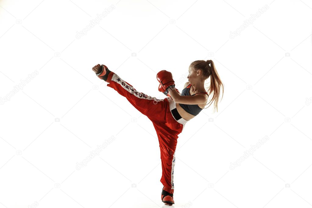 Young female kickboxing fighter training isolated on white background