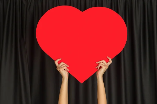 Hands holding the sign of heart on black studio background — ストック写真