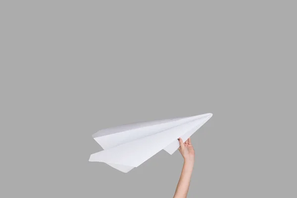 Ruce držící znak papírového letadla na pozadí studia — Stock fotografie