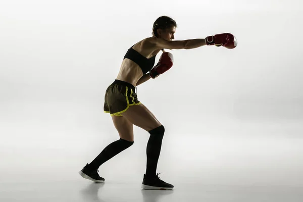 Fit blanke vrouw in sportkleding boksen geïsoleerd op witte studio achtergrond — Stockfoto