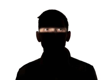 Beyaz stüdyo arka planında karanlıkta bir adamın dramatik portresi..