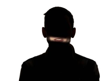 Beyaz stüdyo arka planında karanlıkta bir adamın dramatik portresi..