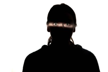 Beyaz stüdyo arka planında karanlıkta bir kızın dramatik portresi..