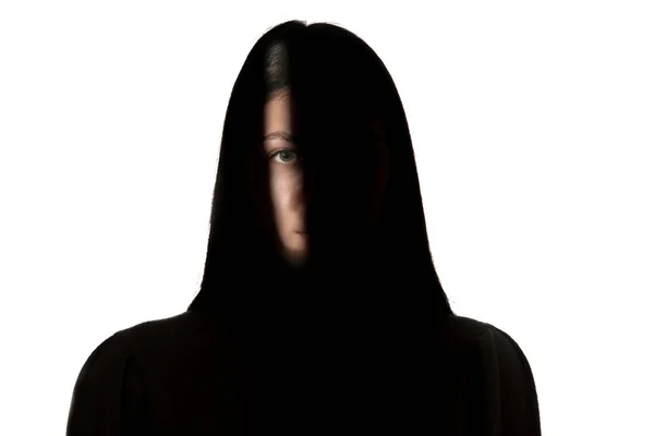 Dramatic portrait of a girl in the dark on white studio background. — ストック写真