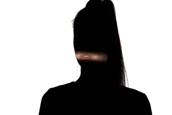 Dramatic portrait of a girl in the dark on white studio background. — ストック写真