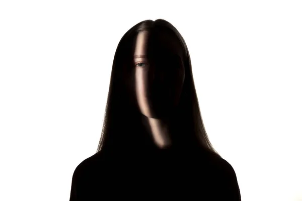 Drammatico ritratto di una ragazza al buio su sfondo bianco studio . — Foto Stock