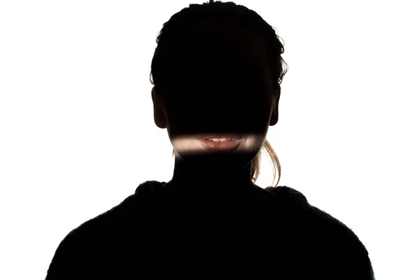 Δραματική προσωπογραφία ενός κοριτσιού στο σκοτάδι σε λευκό φόντο στούντιο. — Φωτογραφία Αρχείου