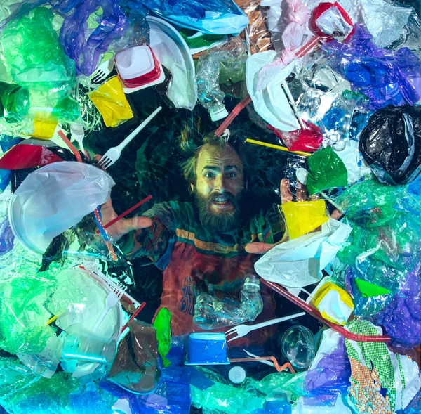 在塑料接受方堆下的海水中溺水的人，环境概念 — 图库照片