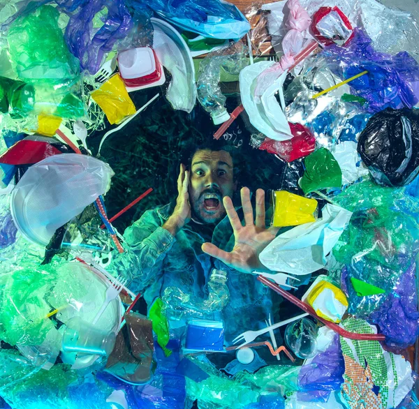 L'uomo che annega nell'acqua dell'oceano sotto plastica recipienti mucchio, concetto di ambiente — Foto Stock