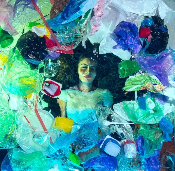 Woman drowning in ocean water under plastic recipients pile, environment concept