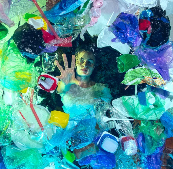 Γυναίκα πνίγεται στο νερό του ωκεανού κάτω από πλαστικό δέκτες σωρό, την έννοια του περιβάλλοντος — Φωτογραφία Αρχείου